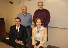 faculty standing together in conference room.