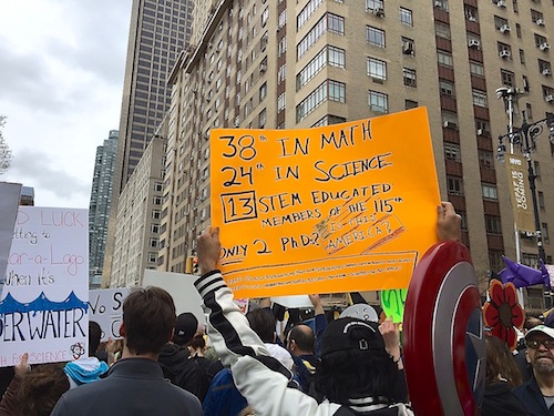 Protester holding up orange sign.