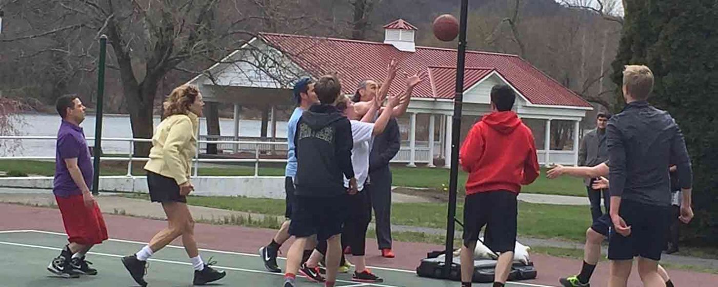 Group playing basketball outside.