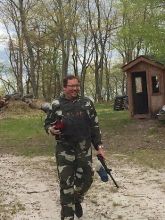 Man in forest playing paintball. 