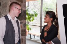 Man speaking to a woman at a conference.