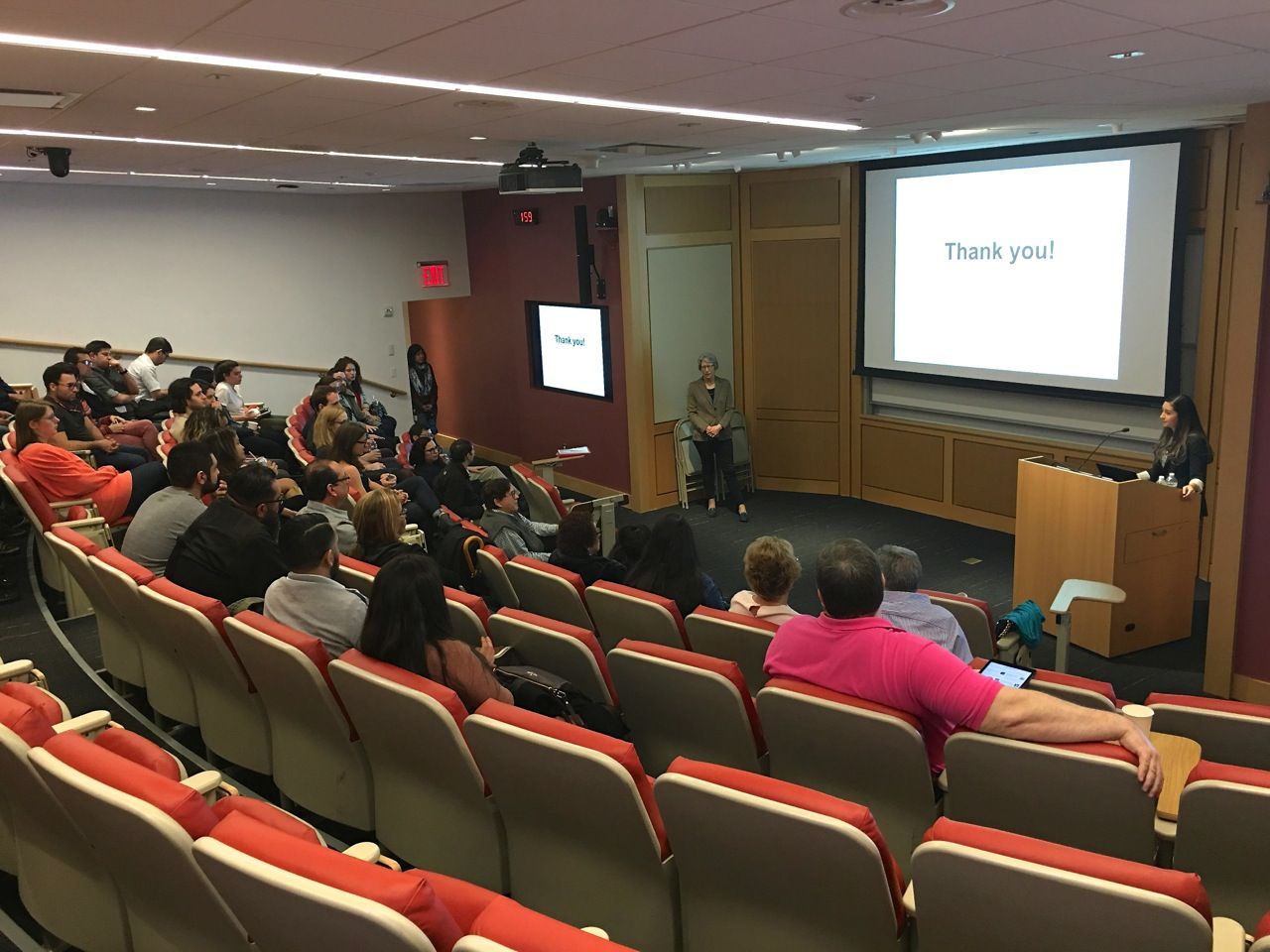 Students and faculty in auditorium for Cynthia Quintero thesis defense. 