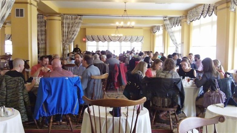 Students sitting at tables inside. Students sitting at tables inside.