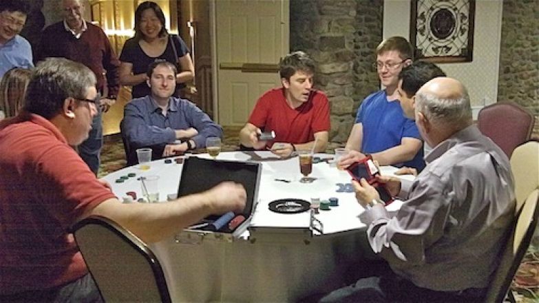 Students playing cards at a table. Students playing cards at a table.
