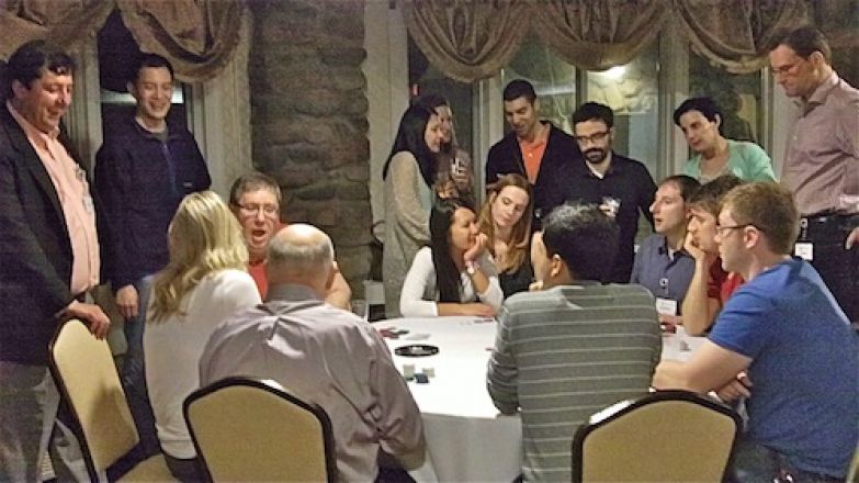 Students playing cards at a table. Students playing cards at a table.