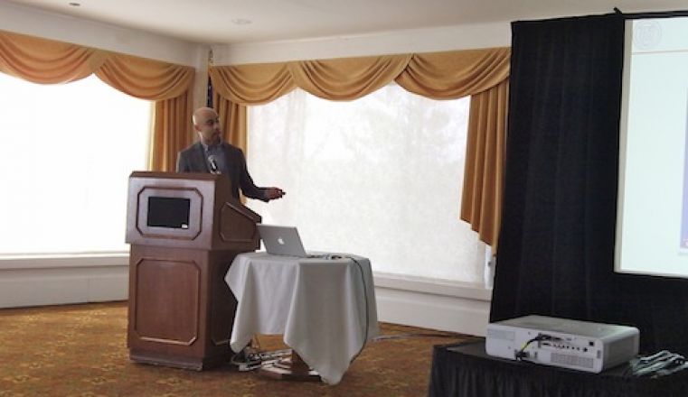 Presenter speaking at a podium. Presenter speaking at a podium.