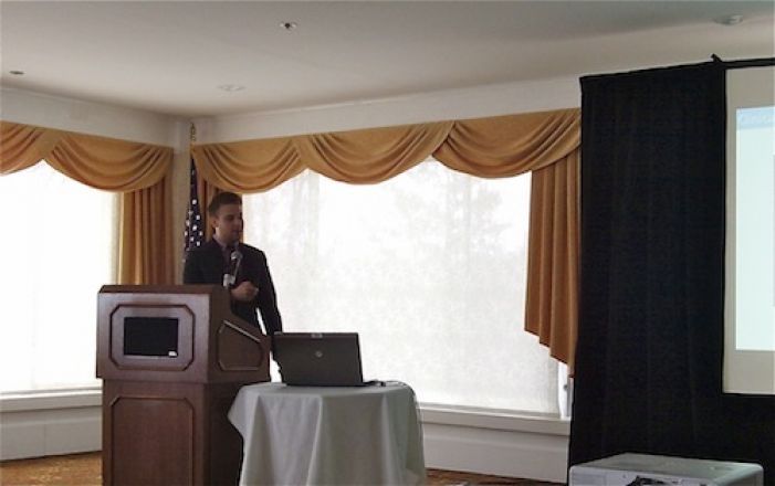 Presenter speaking at a podium. Presenter speaking at a podium.