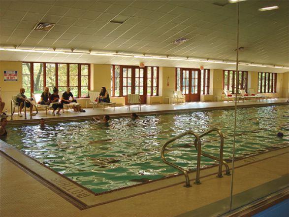 Students sitting near swimming pool.