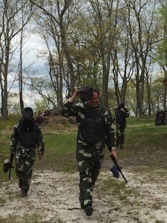 Man in forest playing paintball.