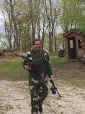 Man in forest playing paintball.